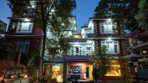 A multi-story residential building with a well-lit entrance and a small outdoor seating area. - Hotel BnB Mhepi (Kathmandu)