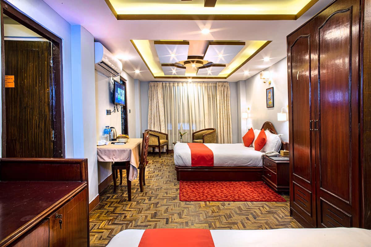 Ein Hotelzimmer mit Bett, Schreibtisch, Stuhl und Kleiderschrank.