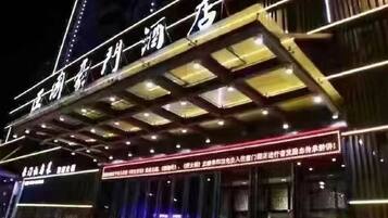 A hotel with a prominent sign and a covered entrance area.
