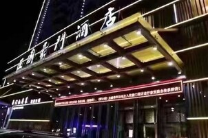 Un hotel con un letrero llamativo y un área de entrada cubierta.