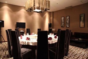 A conference room with a round table, chairs, and a chandelier. - Kingdom Rich Hotel (Fuping)