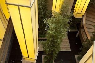 A multi-level building with yellow structural elements and a central vertical garden.