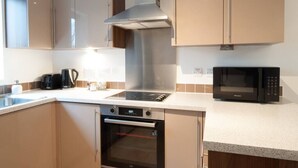 A modern kitchen with stainless steel appliances, a built-in oven, and a microwave.