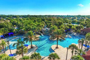 A resort with a large swimming pool surrounded by palm trees and lounge chairs. - The Village, Homes by Villatel (Davenport)