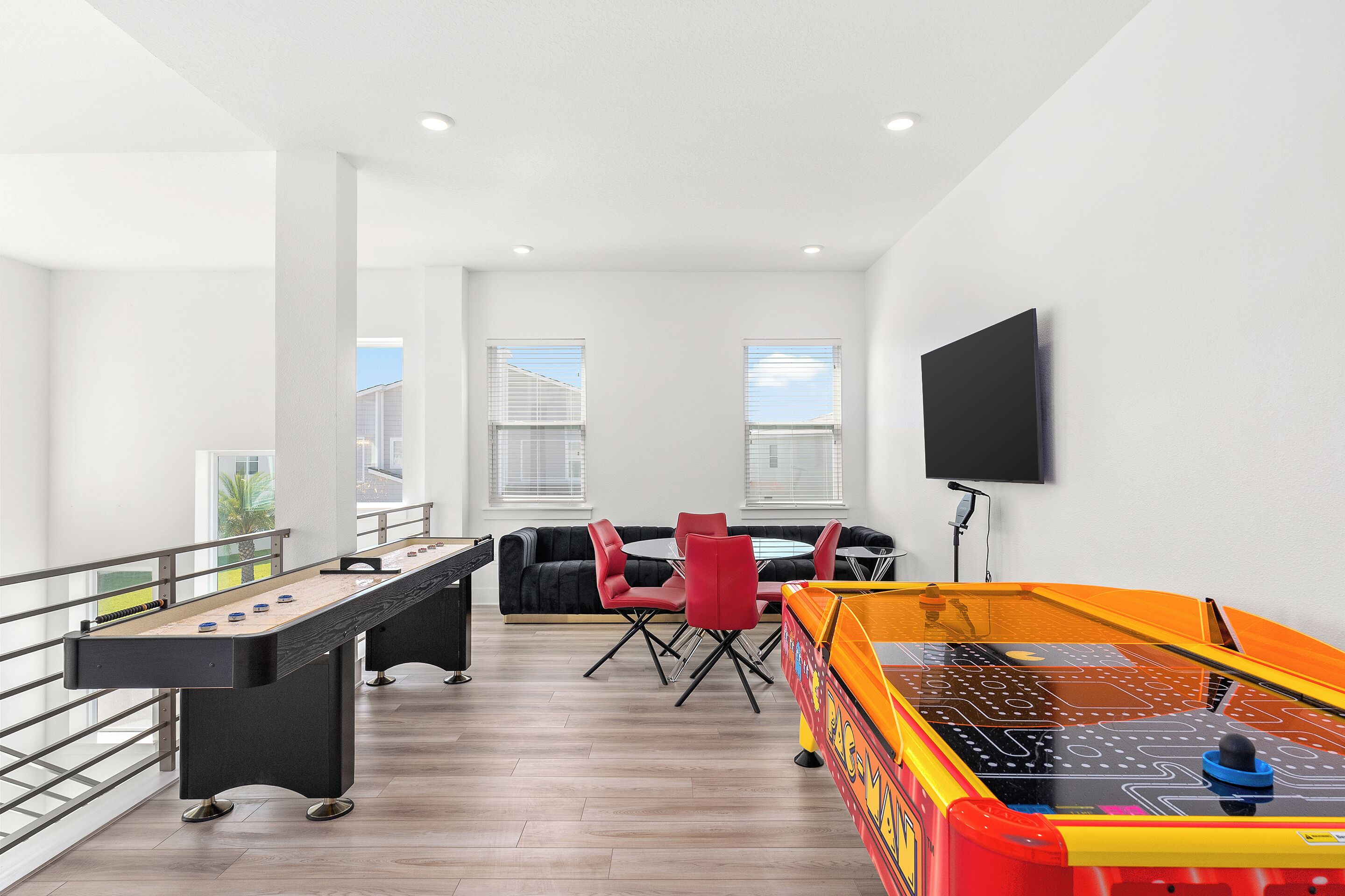 A modern indoor recreational area with a foosball table, pool table, and seating area.