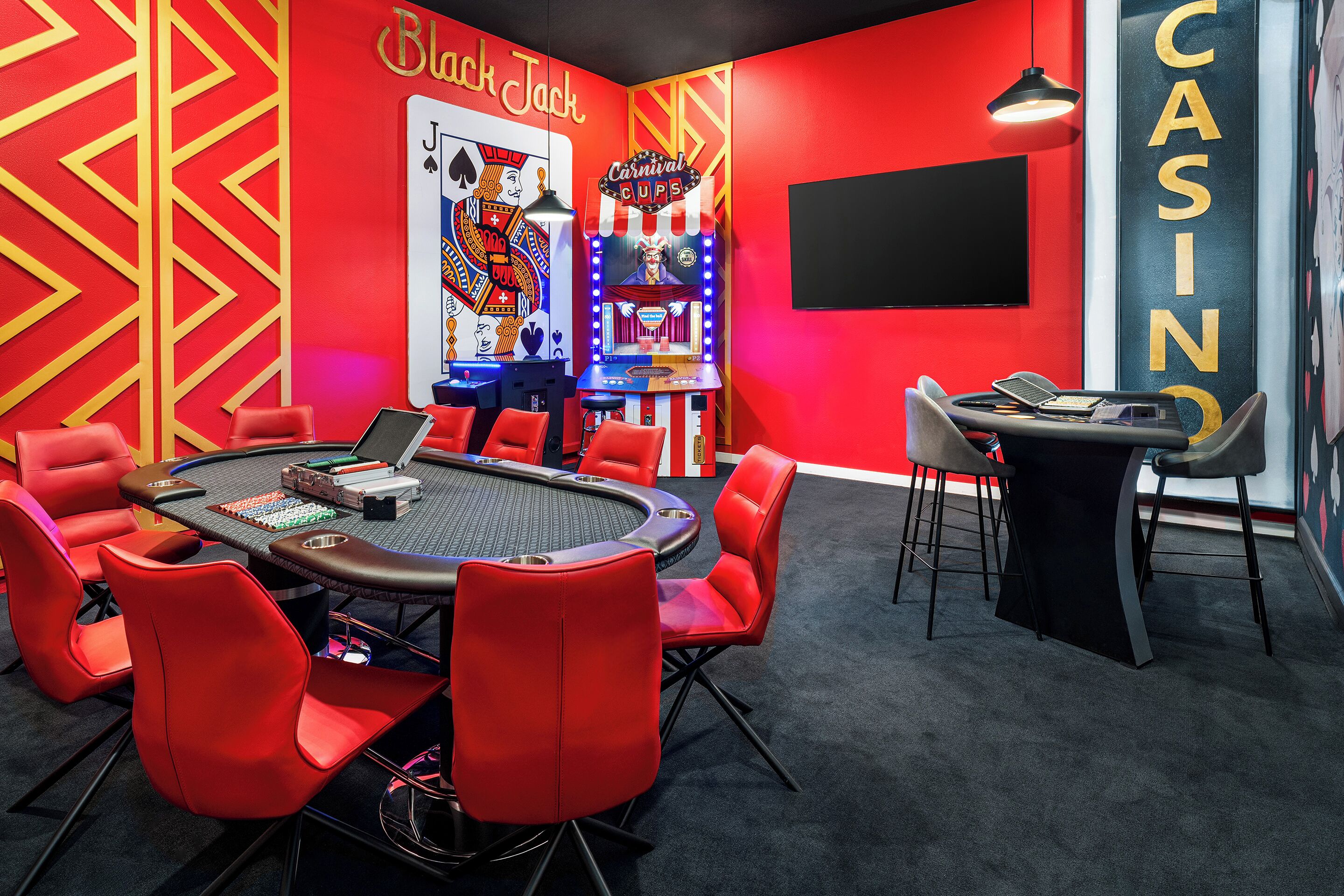 A casino-themed room with a blackjack table, red chairs, and a large 'Casino' sign.