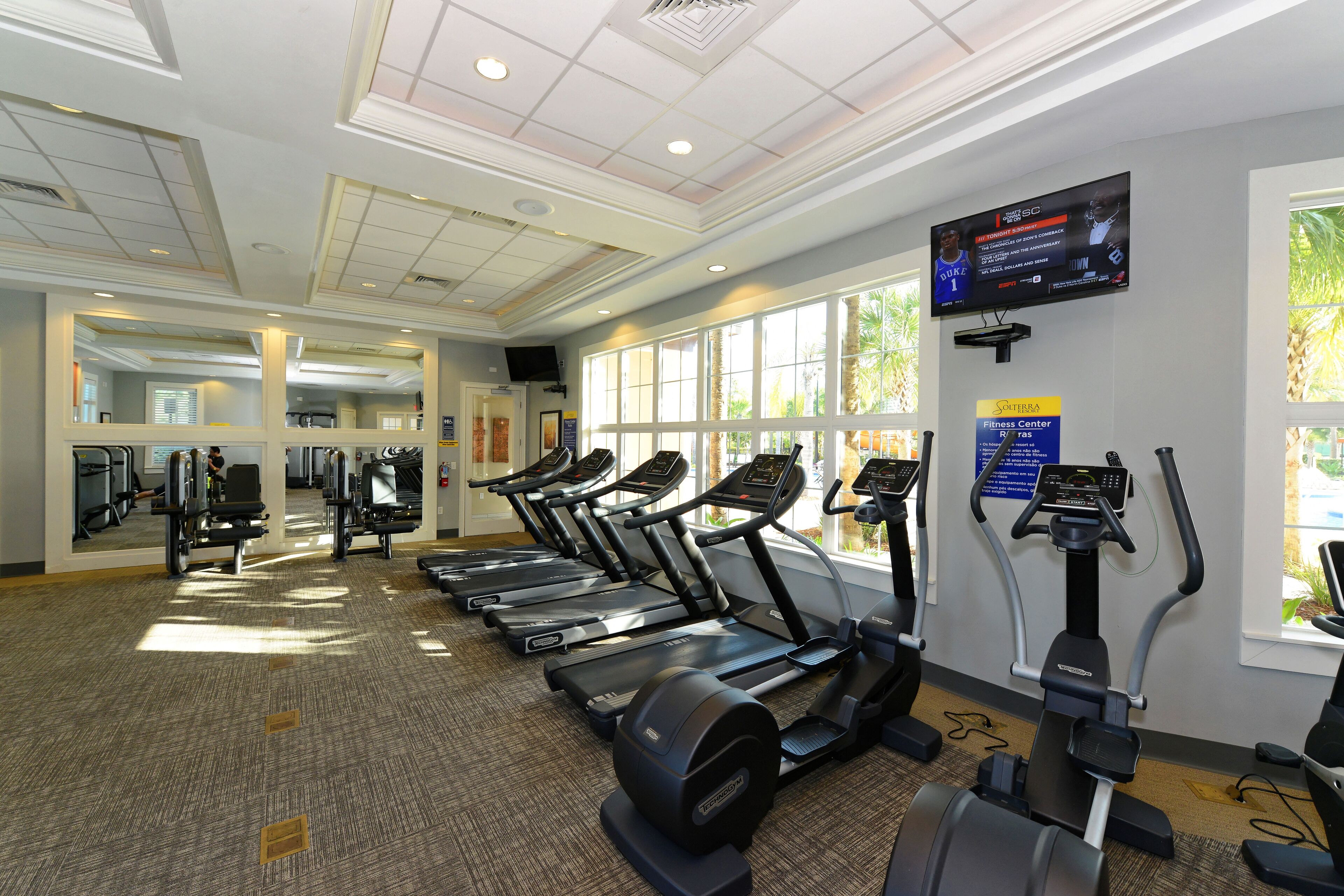 A fitness center with treadmills, elliptical machines, and weight equipment.