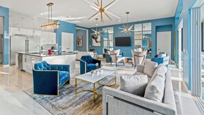 A modern living space with a kitchen, dining area, and seating area. - The Village, Homes by Villatel (Davenport)