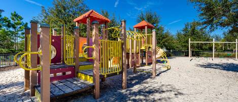 A playground with climbing structures, slides, and a fenced area.