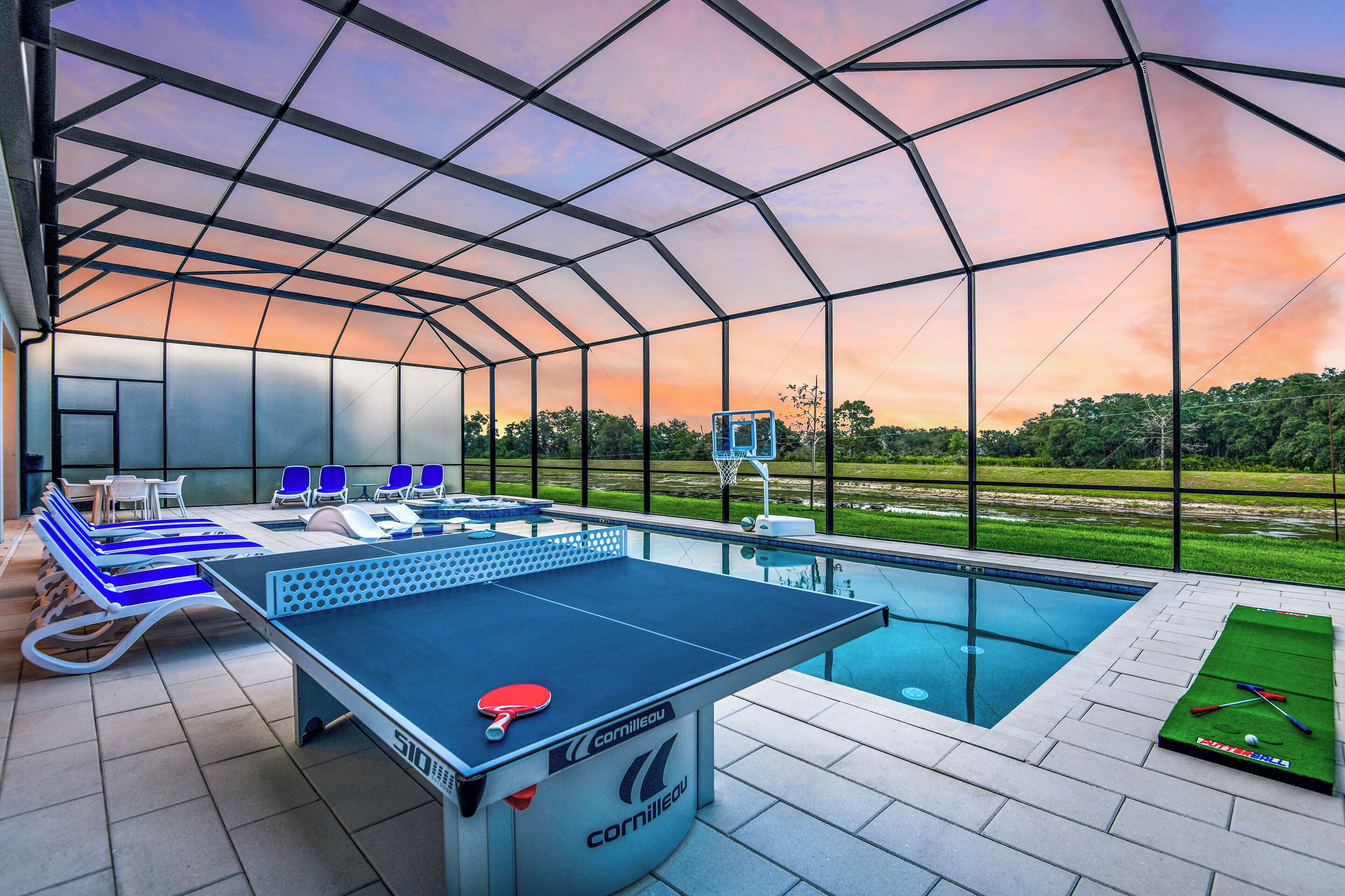 An indoor recreational area with a ping pong table, chairs, a pool, and a foosball table.