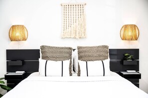 A modern bedroom with a large bed, two nightstands, a wall-mounted macrame piece, and two textured wall lamps. - MIMO5-1 | cozy corner of Miami's Modern District (Miami)