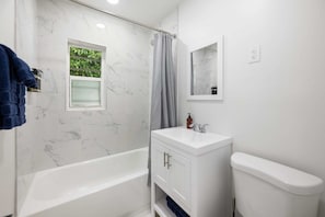 Bañera, secador de pelo, toallas y champú
