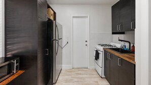 Une cuisine compacte équipée d’un réfrigérateur, d’un four, d’un four à micro-ondes et d’une cuisinière.