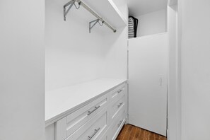 A white closet with a metal rack and a wooden floor. - MIMO5-4 | cozy corner of Miami's Modern District (Miami)