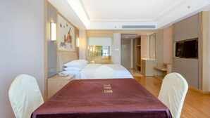 Una habitación de hotel con una cama, un escritorio, una silla, un televisor y una ventana.