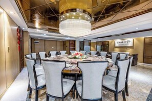 A conference room with a round table, chairs, a chandelier, and a decorative centerpiece. - Vienna International Hotel (Guiyang Yunyan District Future Ark Branch) (Guiyang)