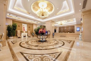 A hotel lobby with a central reception desk, a chandelier, and a patterned floor. - Vienna International Hotel (Guiyang Yunyan District Future Ark Branch) (Guiyang)