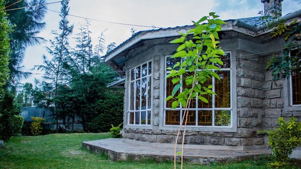 A stone house with a porch and large windows.