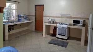 A compact kitchen with a gas stove, microwave, and sink.