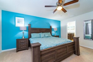 A bedroom with a bed, two nightstands, a ceiling fan, and a large mirror. - Extraordinary 5 BR Villa, Pool, Resort - by Blue Sky Villas (Kissimmee)