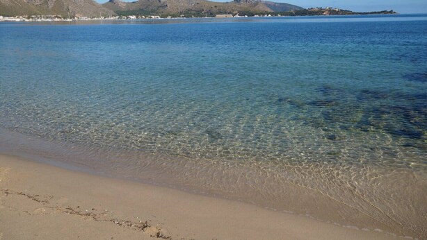A beach with clear shallow waters, a sandy shore, and distant mountains. - Villa Volentina, private pool, pool table, free WiFi (Puerto de Pollensa)