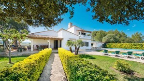 A two-story house with a stone pathway leading to the entrance, surrounded by well-maintained hedges and a small garden. - Villa Volentina, private pool, pool table, free WiFi (Puerto de Pollensa)