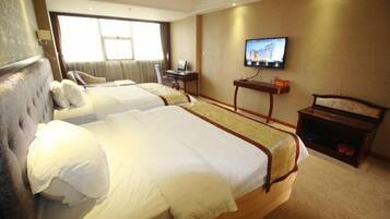 A hotel room with two beds, a television on the wall, and a desk with a chair.