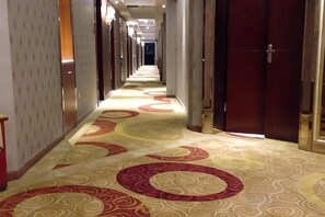 A hotel corridor with patterned carpet, doors, and a long hallway. - Bierga Grand Hotel (Fuqing)
