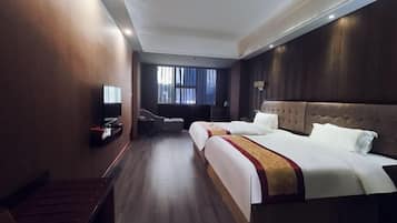 A hotel room with a large bed, a TV, a desk, and a window with curtains.