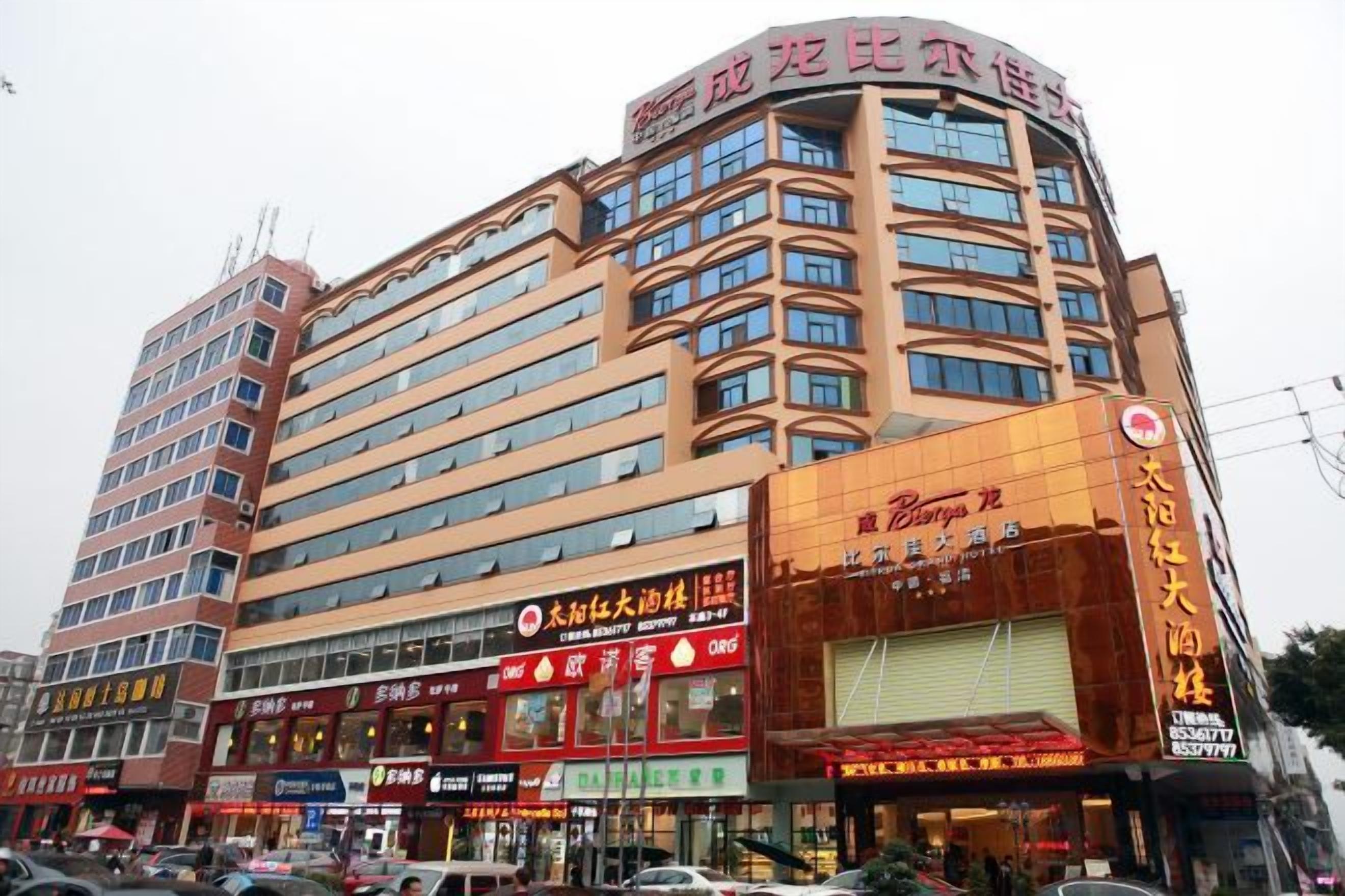 A multi-story hotel with a prominent corner entrance, multiple balconies, and a variety of commercial establishments on the ground floor.