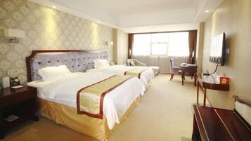 A hotel room with two beds, a desk, a chair, and a television.