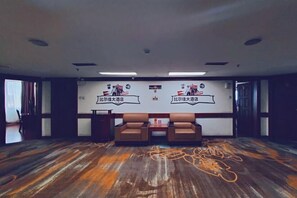 A conference room with two brown leather sofas, a whiteboard with text, and a patterned wooden floor. - Bierga Grand Hotel (Fuqing)