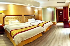 A hotel room with two beds, a wooden floor, and a red door. - Bierga Grand Hotel (Fuqing)