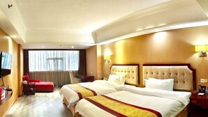 Habitaci ón de hotel con dos camas, un sofá rojo, televisión y un ventanal con cortinas.