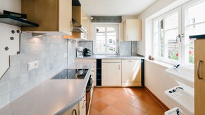 A modern kitchen with a built-in oven, a coffee maker, and a window with a view of the outside. - Allgäu a. Forggensee - near Neuschwanstein, apartment f. Couples and family, 2 bedrooms, WLAN (Roßhaupten)