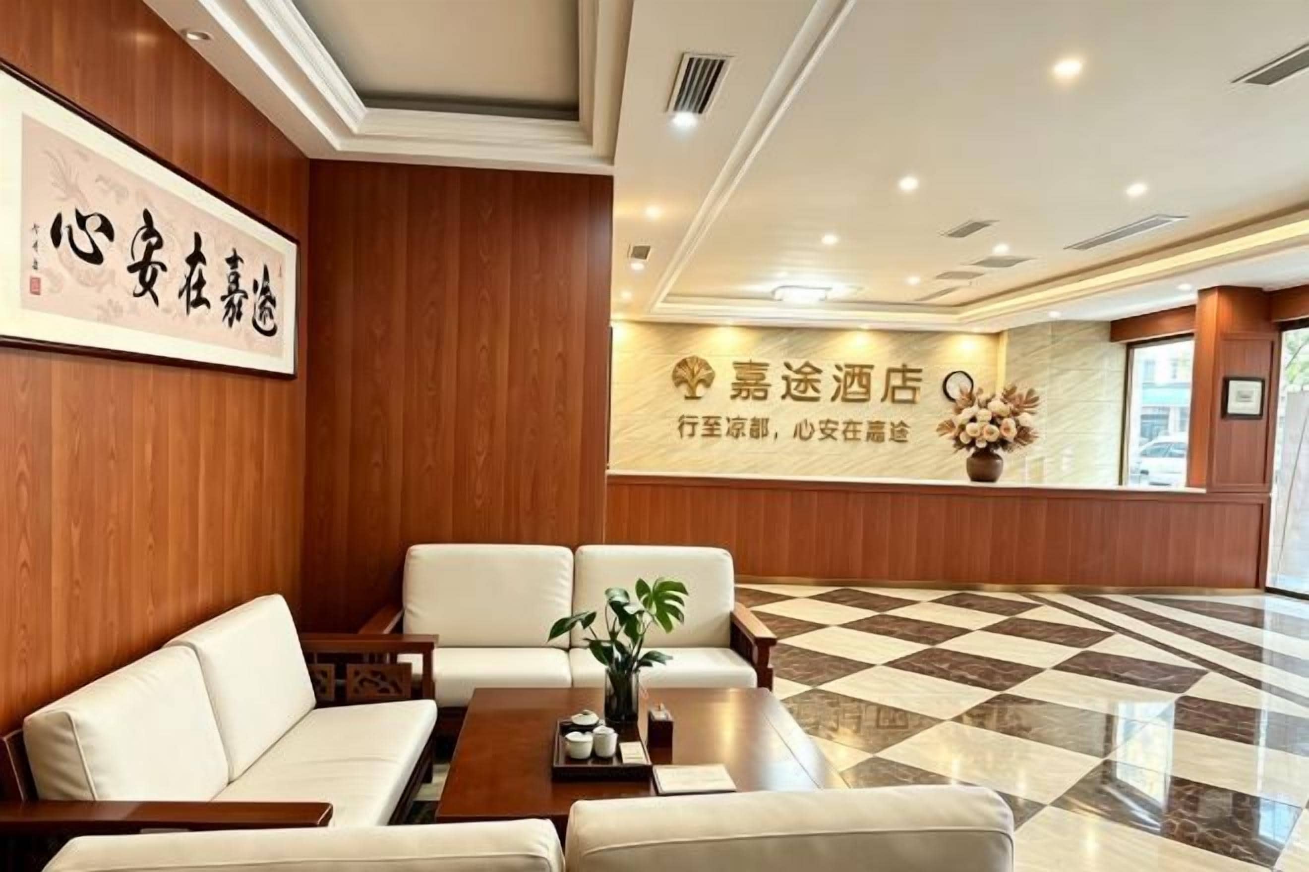A hotel lobby with a reception desk, seating area, and a checkered floor.