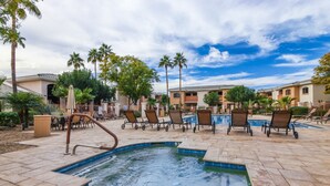 Un área de piscina con sillones de descanso y una piscina pequeña.