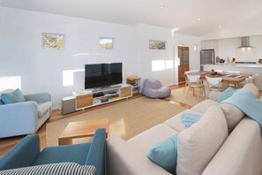 Relax in a spacious living area with a sofa set, flat-screen TV, and dining table.