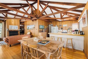 L’intérieur d’un chalet rustique comprend un coin repas, une cuisine et un espace de vie.