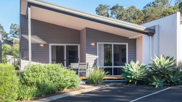 A modern single-story building with a covered patio area, large sliding glass doors, and a parking lot. - Villa on the Cape: Relaxed Hideaway near Town (Dunsborough)