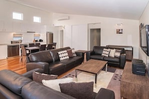A modern living room with leather sofas, a coffee table, and a flat-screen TV. - Villa on the Cape: Relaxed Hideaway near Town (Dunsborough)