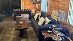 Une pièce chaleureuse avec un plafond en bois, un canapé, une table basse et une lampe.