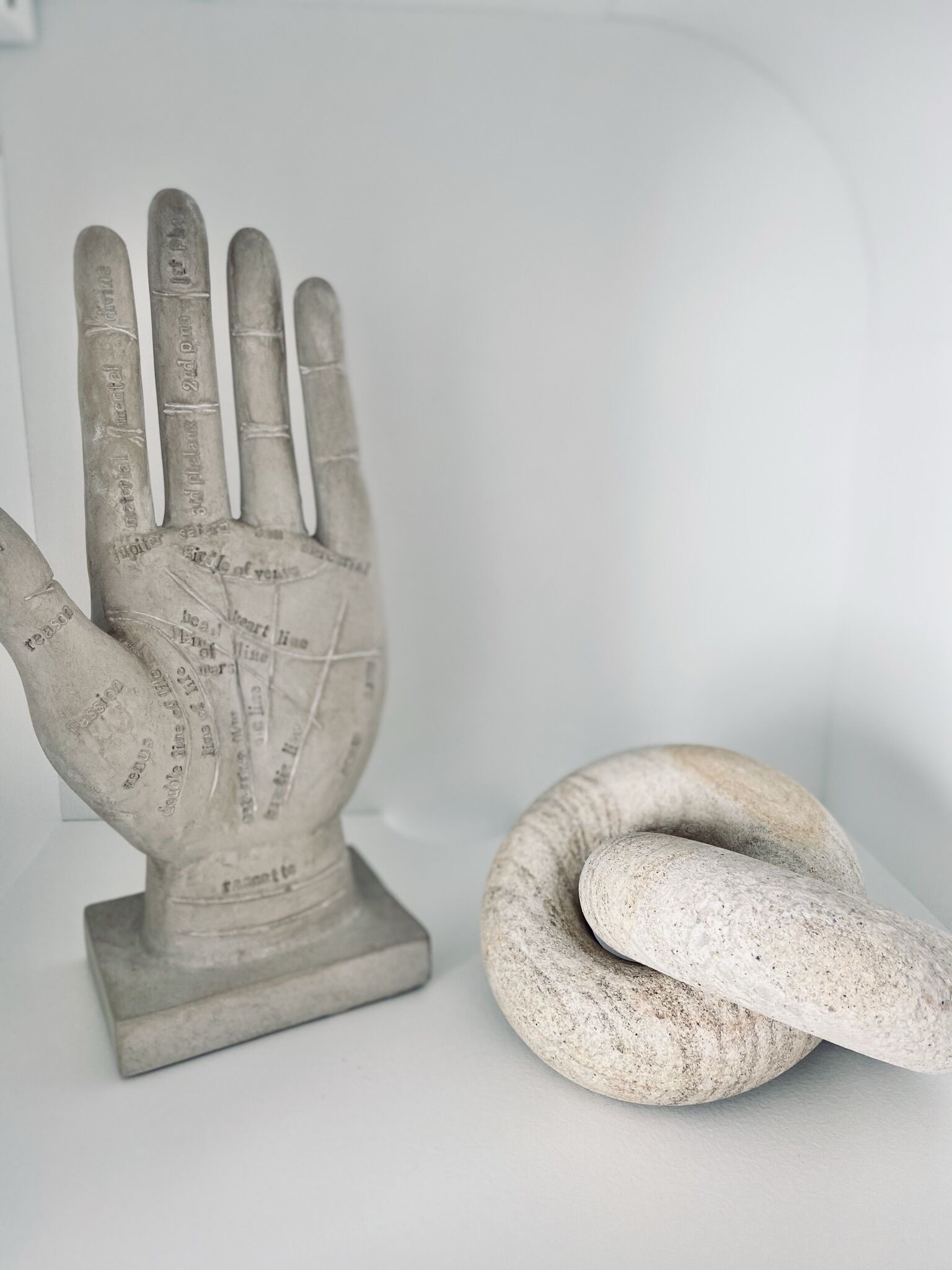 Una escultura de una mano con inscripciones y una serpiente enrollada a su lado.