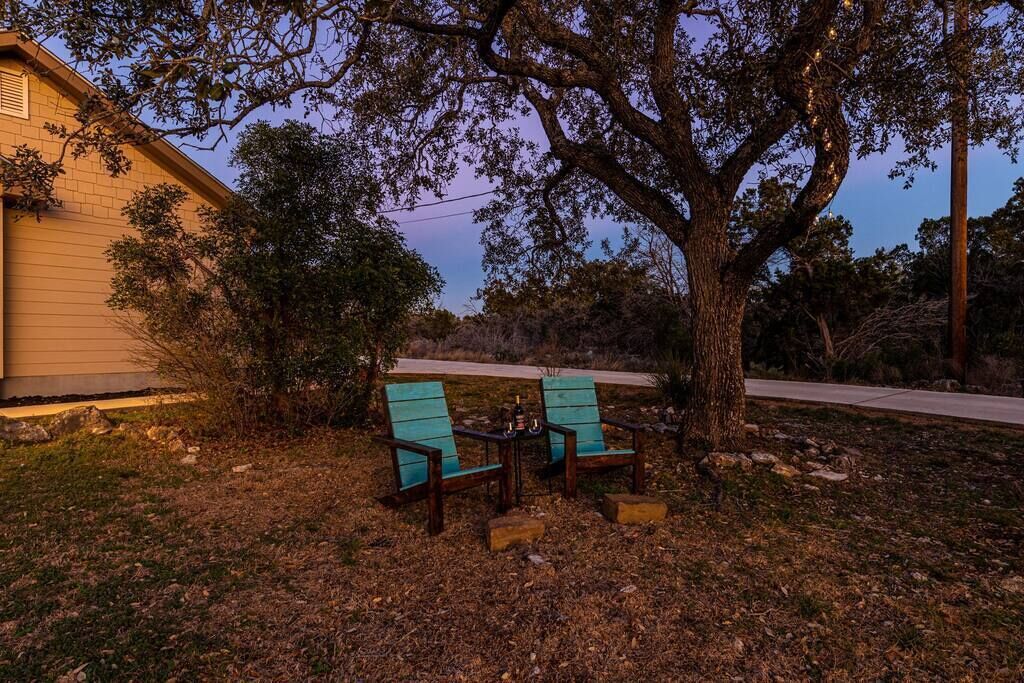 A tree with a bench and a table in a yard.