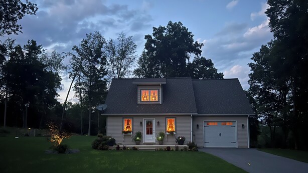 Une maison à deux étages avec un garage, une pelouse bien entretenue et une antenne parabolique.
