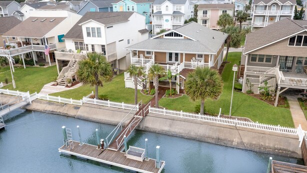 A residential area with houses, a dock, and a waterway. - 4 BDRM CANAL HOUSE WITH LARGE OUTDOOR LIVING SPACE (Ocean Isle Beach)
