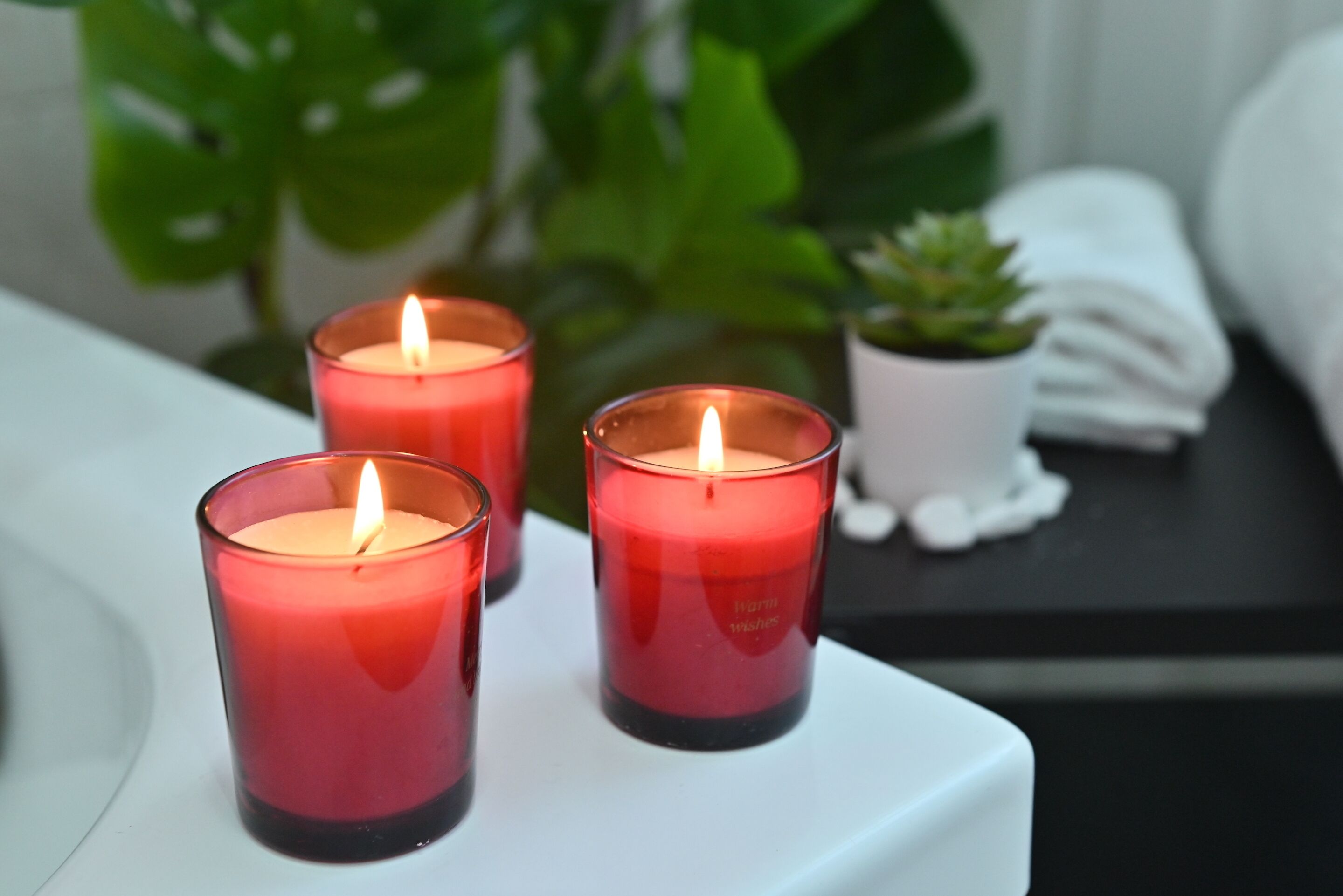Three red candles on a white tray.