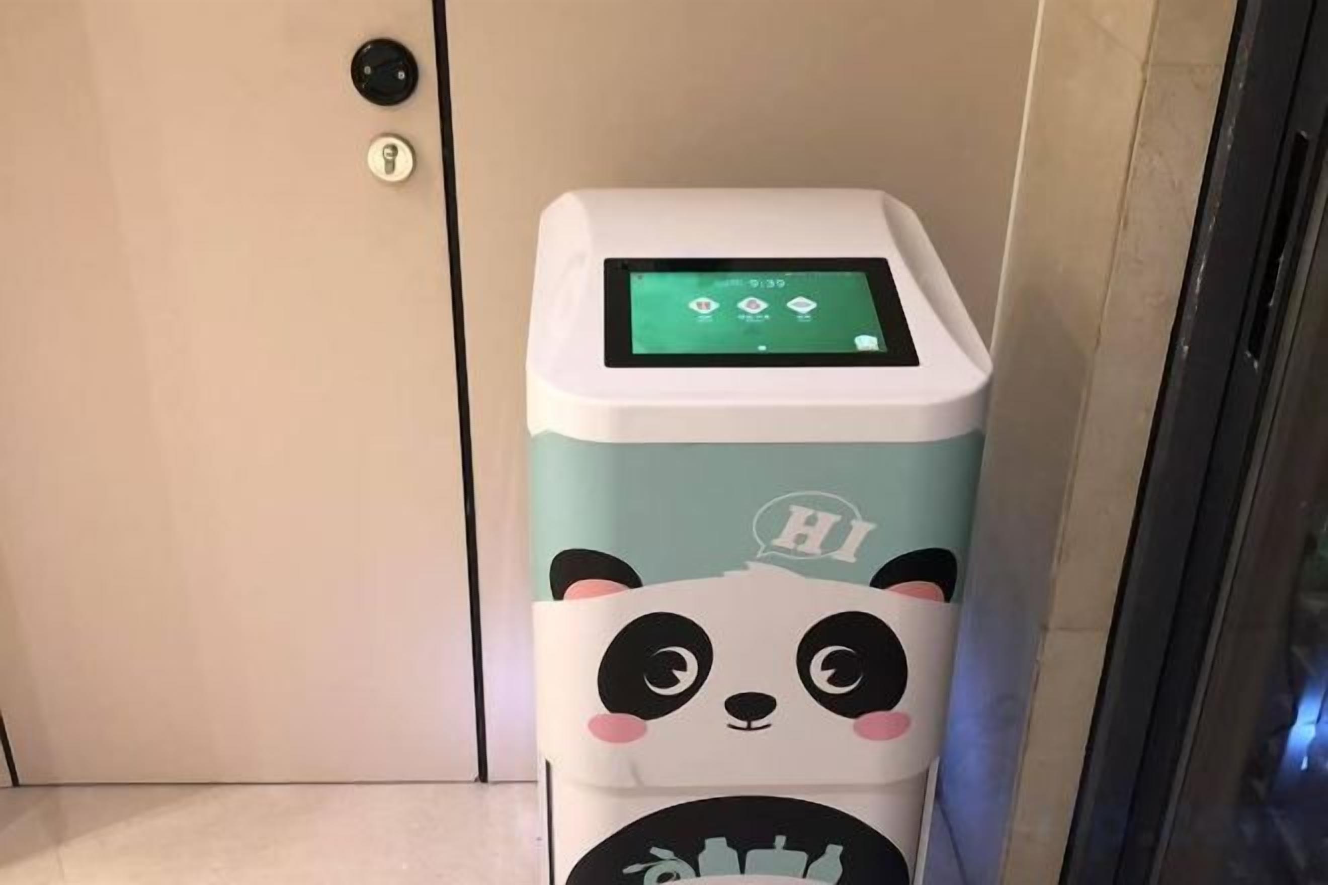 A self-service kiosk with a panda design, located in a hotel lobby.