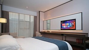 A modern hotel room with a large bed, a flat-screen TV mounted on the wall, and a desk with a chair. - Yamei Hotel (Xiangtan Youyi) (Xiangtan)