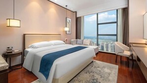 A hotel room with a large bed, a desk, a chair, a view of the city, and a large window. - Yamei Hotel (Xiangtan Youyi) (Xiangtan)